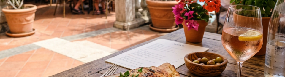 Calzone on plate with tomato sauce and basil, glass of rosé, seaside terrace dining