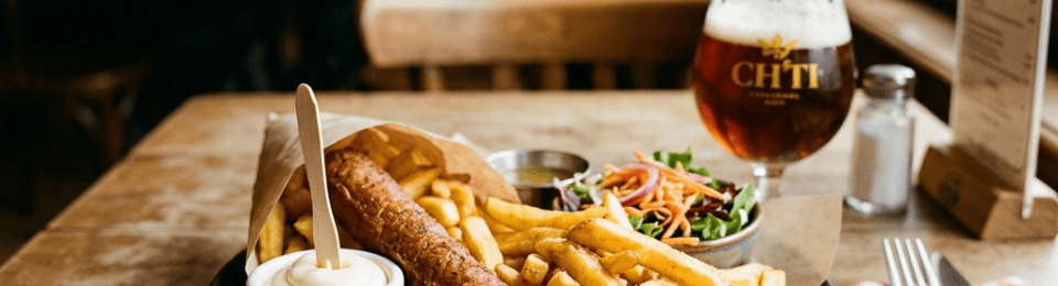 Sausage, chips, salad, and CH’TI beer on a pub table